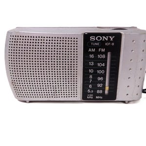 May include: Silver vintage Sony ICF-8 radio with a black control panel. The radio has a speaker grill with small holes and a tuning dial. The radio has the text "SONY" and "ICF-8" printed on the front.