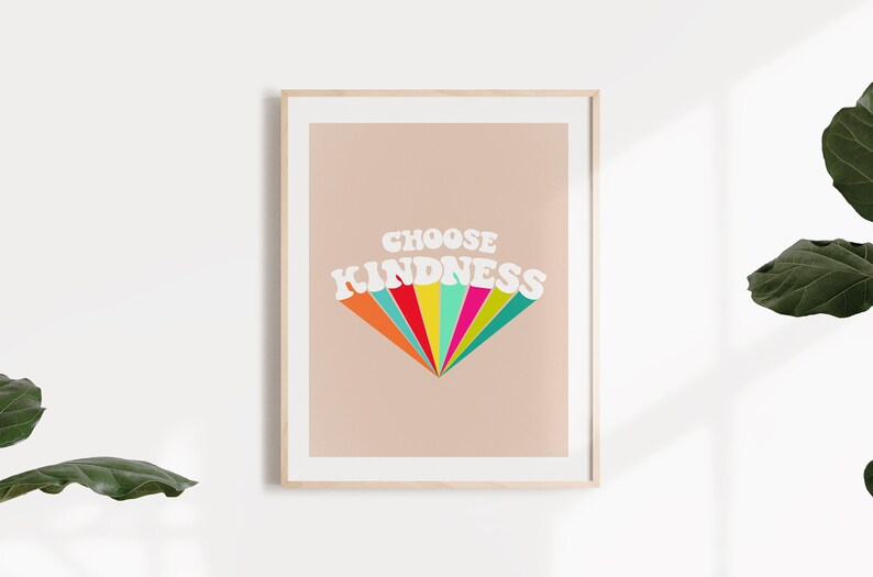 May include: A framed print with a peach background and the text "CHOOSE KINDNESS" in white with a rainbow-colored design behind the text.