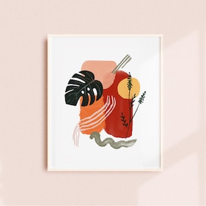 May include: Abstract art print featuring a red, orange, and pink abstract design with a green leaf and a yellow circle. The print is framed in a white frame.