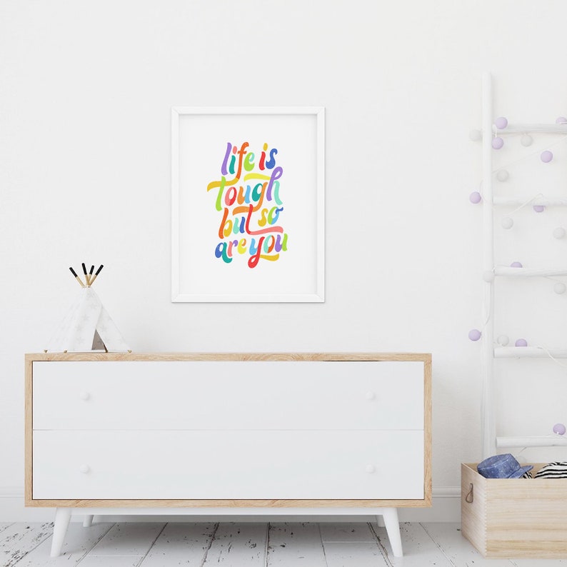 May include: A white framed print with the text "life is tough but so are you" in colorful, handwritten lettering.