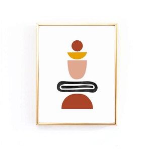 Op de afbeelding: Een ingelijst print met een abstract ontwerp met geometrische vormen in tinten rood, oranje, geel en roze. De vormen zijn op elkaar gestapeld, waardoor een uitgebalanceerde en symmetrische compositie ontstaat.