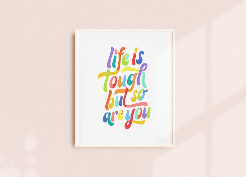May include: A framed print with the text "life is tough but so are you" in colorful, handwritten lettering.