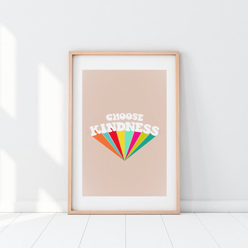 May include: A framed print with a peach background and the text "Choose Kindness" in white letters with a rainbow arc behind the text.