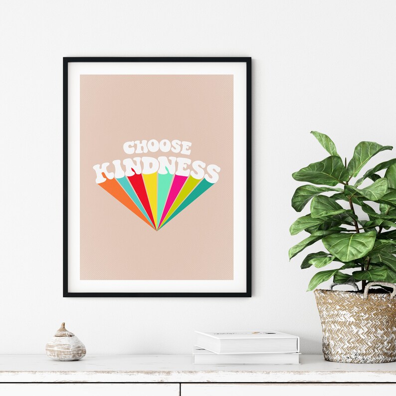 May include: A framed print with a peach background and the text "CHOOSE KINDNESS" in white letters with a rainbow-colored fan behind the text.
