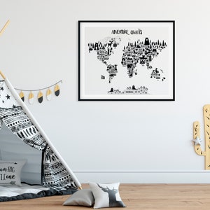 以下が含まれることがあります： 黒と白の世界地図のプリントで、黒いフレームに「アドベンチャーが待っている」というテキストが書かれています。地図には、さまざまな場所やアクティビティを表す小さな黒いアイコンがぎっしり詰まっています。プリントは、ティピーと木製のサボテンのある部屋の白い壁に掛けられています。