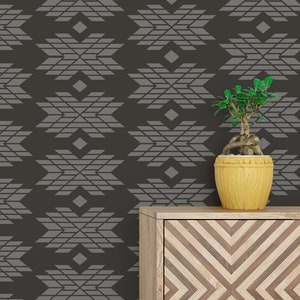 May include: A wooden cabinet with a geometric pattern on the front. The cabinet is sitting on a white floor in front of a wall with a dark gray geometric pattern wallpaper. A small potted plant is on top of the cabinet.