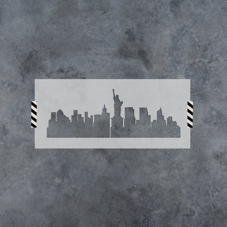 May include: A stencil of the New York City skyline with the Statue of Liberty in the center. The stencil is made of a thin, white material and is perfect for creating a unique and stylish design on walls, furniture, or other surfaces.