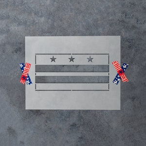 May include: A gray stencil of the flag of Washington, D.C. with three stars and three red and white stripes. Two small American flag stickers are on the gray background.