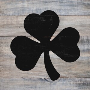 May include: A black shamrock silhouette on a woodgrain background.