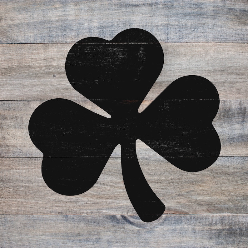 May include: A black shamrock silhouette on a woodgrain background.