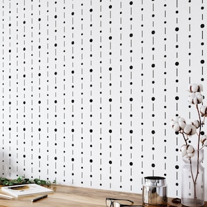 May include: A white wallpaper featuring a repeating pattern of vertical black lines interspersed with solid black dots. The design creates a clean, geometric aesthetic across the surface, providing a consistent and structured visual texture.
