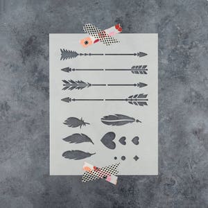 May include: A white stencil sheet with a variety of designs, including arrows, feathers, hearts, and geometric shapes. The stencil is perfect for crafting and DIY projects.