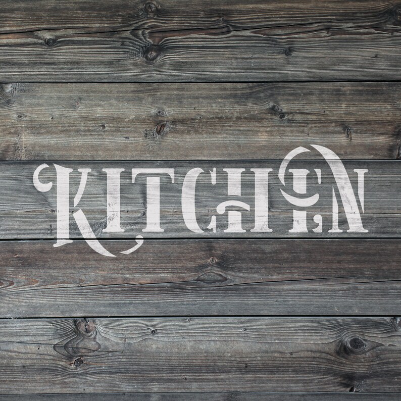May include: A rustic wooden sign with the word "KITCHEN" in large, white, decorative lettering. The sign is made of weathered, gray-toned wooden planks, creating a vintage aesthetic. The text is centered and stands out against the wood.