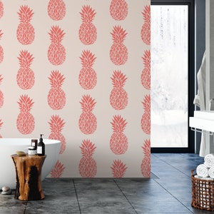 May include: A bathroom with a white bathtub and a pink pineapple patterned wallpaper. The bathroom has a large window and a wooden stool.