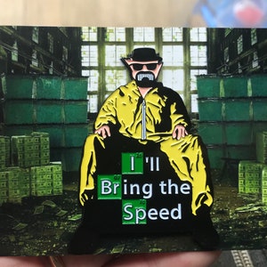 May include: A yellow and black enamel pin featuring a cartoon character wearing a yellow jumpsuit and a black hat. The character is sitting on a pile of money. The pin says "I'll Bring the Speed" with the letters "I" and "Br" replaced with the chemical symbols for the elements iodine and bromine.