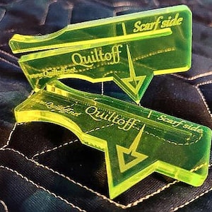 Peut inclure: Deux outils de quilting en plastique jaune vif avec le texte "Quiltoff" et "Scarf side" imprimé dessus. Les outils sont conçus pour aider les quilteurs à créer des coutures parfaites.