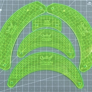 May include: Four green plastic quilting templates with the text "Quiltoff Just Keep Quilting" and a website address. The templates are in the shape of a crescent moon and are numbered 1, 2, and 3.