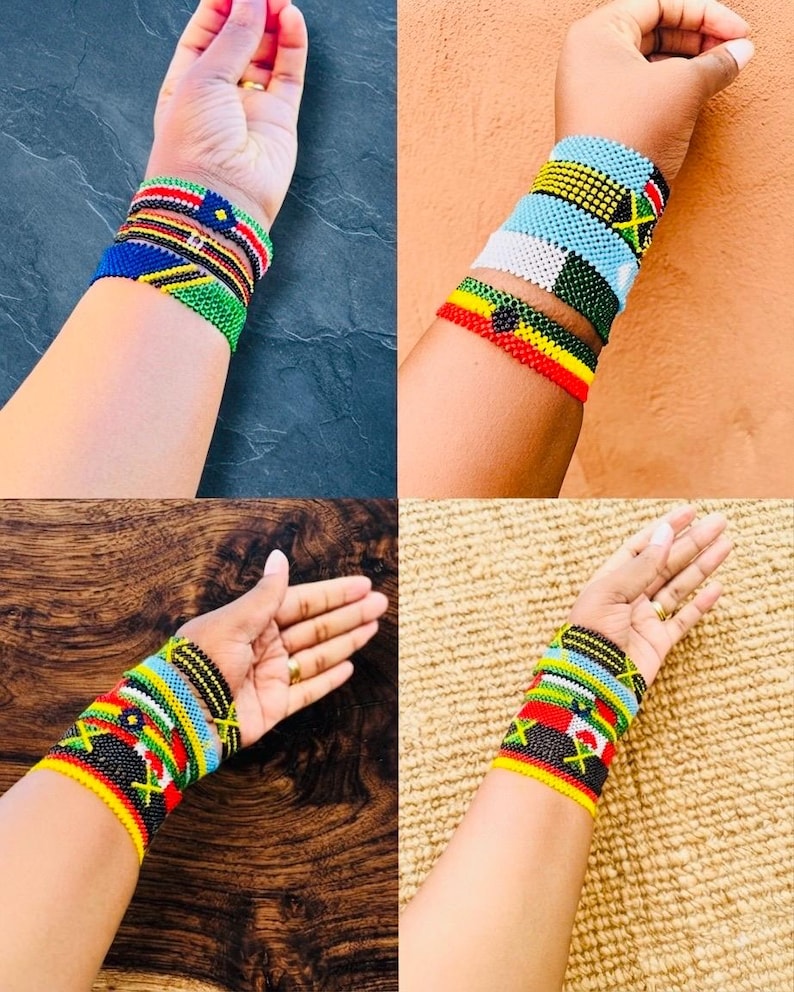 May include: A collection of four sets of multi-colored beaded bracelets featuring intricate geometric patterns and vibrant flag-inspired designs. Each bracelet is crafted from small, uniform glass beads arranged in horizontal rows, showcasing various color combinations including red, yellow, green, black, blue, and white.