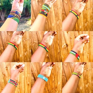 May include: A collection of nine beaded bracelets featuring various flag designs and geometric patterns in vibrant colors including red, green, yellow, black, blue, and white. Each bracelet is crafted with small seed beads arranged in rows.