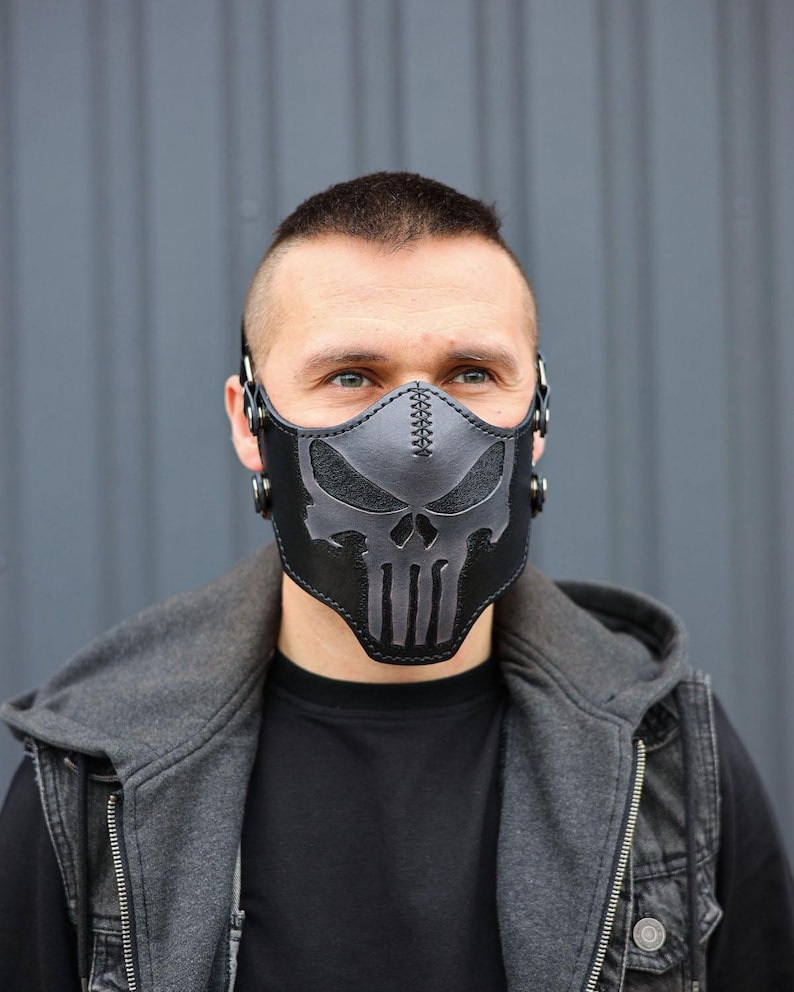 Peut inclure: Un masque facial en cuir noir avec un motif de cr&acirc;ne. Le masque a des sangles qui passent autour des oreilles et une boucle &agrave; l'arri&egrave;re.