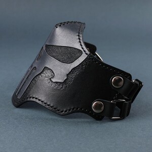 Peut inclure: Masque de moto en cuir noir avec un motif de cr&acirc;ne. Le masque a deux sangles r&eacute;glables avec des boucles m&eacute;talliques.