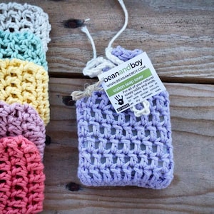 May include: A purple crocheted soap saver with a white label that reads "beanandboy WWW.BEANANDBOY.COM cotton soap saver For all of your natural soapy odds and ends. Wash before first use at 30 with similar colours. BY HAND Let dry between uses."