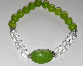May include: A green jade stone bracelet with clear crystal beads and silver accents. The bracelet has a large green jade stone in the center.