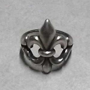Puede incluir: Un anillo de plata con un diseño de flor de lis. El anillo está hecho de metal y tiene un acabado liso.
