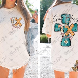 May include: White t-shirt with a teal blue cross with floral accents and the text "God Bless Texas" on the back. The front of the shirt has a floral design with the letters "TX" and the word "Texas" underneath.