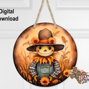 May include: A round wooden door hanger featuring a painted image of a scarecrow wearing a blue and white checked shirt and dungarees. The scarecrow is surrounded by sunflowers and tall grass. The background is a warm orange colour.