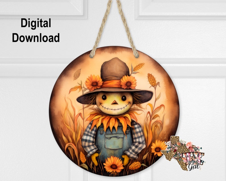 May include: A round wooden door hanger featuring a painted image of a scarecrow wearing a blue and white checked shirt and dungarees. The scarecrow is surrounded by sunflowers and tall grass. The background is a warm orange colour.