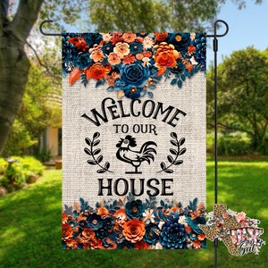 May include: A welcome to our house garden flag with a rooster design. The flag features a burlap background with blue and orange flowers and the text "Welcome to our house".
