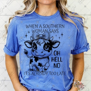 Könnte beinhalten: Ein blaues T-Shirt mit einer schwarz-weißen Illustration einer Kuh mit Schleife. Der Text "When a Southern Woman Says Oh Hell No It's Already Too Late" ist auf dem T-Shirt aufgedruckt.