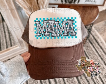 May include: A brown and white trucker hat with a blue and white checkered pattern and the word "MAMA" in rhinestones. The hat has a brown mesh back and a brown brim.