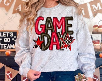 May include: A light gray sweatshirt with the words "GAME DAY" in red and black, accented with red stars and a checkered star. The sweatshirt is part of a game day theme.