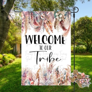 May include: Welcome to our Tribe garden flag with a bohemian style design featuring feathers, flowers, and a white background.