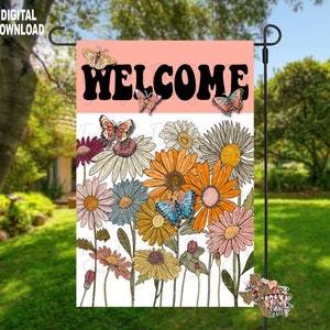 Puede incluir: Una bandera de jardín de bienvenida rosa y blanca con una fuente retro. La bandera presenta un diseño floral con mariposas y un mensaje de bienvenida.