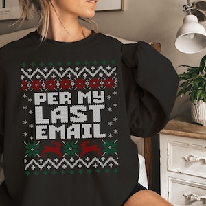 Könnte beinhalten: Schwarzes Sweatshirt mit festlichem Design. Das Design enthält den Text "PER MY LAST EMAIL" in weißen Blockbuchstaben, umgeben von Schneeflocken, Rentieren und geometrischen Mustern in Rot, Grün und Weiß. Ein bequemes, lässiges Oberteil.