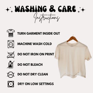 Peut inclure: Un t-shirt cr&egrave;me sur un cintre en bois, avec des instructions de lavage et d'entretien en texte noir. Les instructions incluent de retourner le v&ecirc;tement, de laver en machine &agrave; froid et d'&eacute;viter le repassage sur l'impression, le blanchiment, le nettoyage &agrave; sec et le s&eacute;chage &agrave; basse temp&eacute;rature.