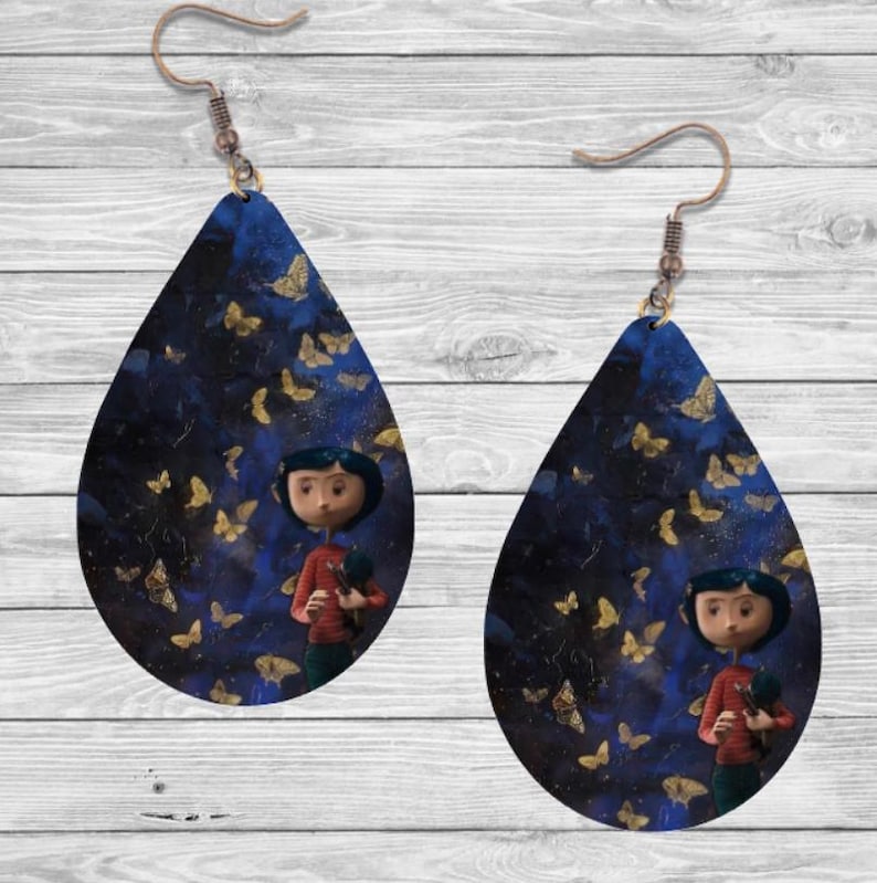Peut inclure: Boucles d'oreilles en forme de goutte d'eau avec un fond bleu fonc&eacute; et des papillons dor&eacute;s. Chaque boucle d'oreille pr&eacute;sente un personnage de dessin anim&eacute; en chemise rouge et pantalon vert. Les boucles d'oreilles ont des crochets d'oreille couleur cuivre.