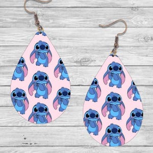 May include: A pair of pink teardrop-shaped earrings with a repeating pattern of blue Stitch characters from the Disney movie Lilo & Stitch.