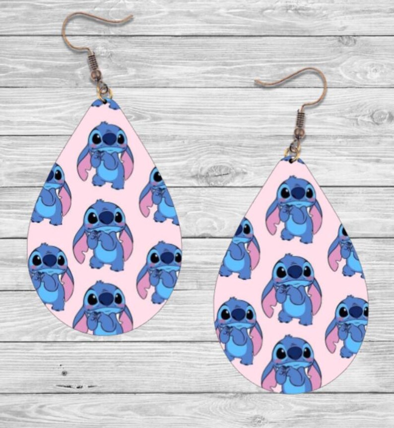 May include: A pair of pink teardrop-shaped earrings with a repeating pattern of blue Stitch characters from the Disney movie Lilo & Stitch.