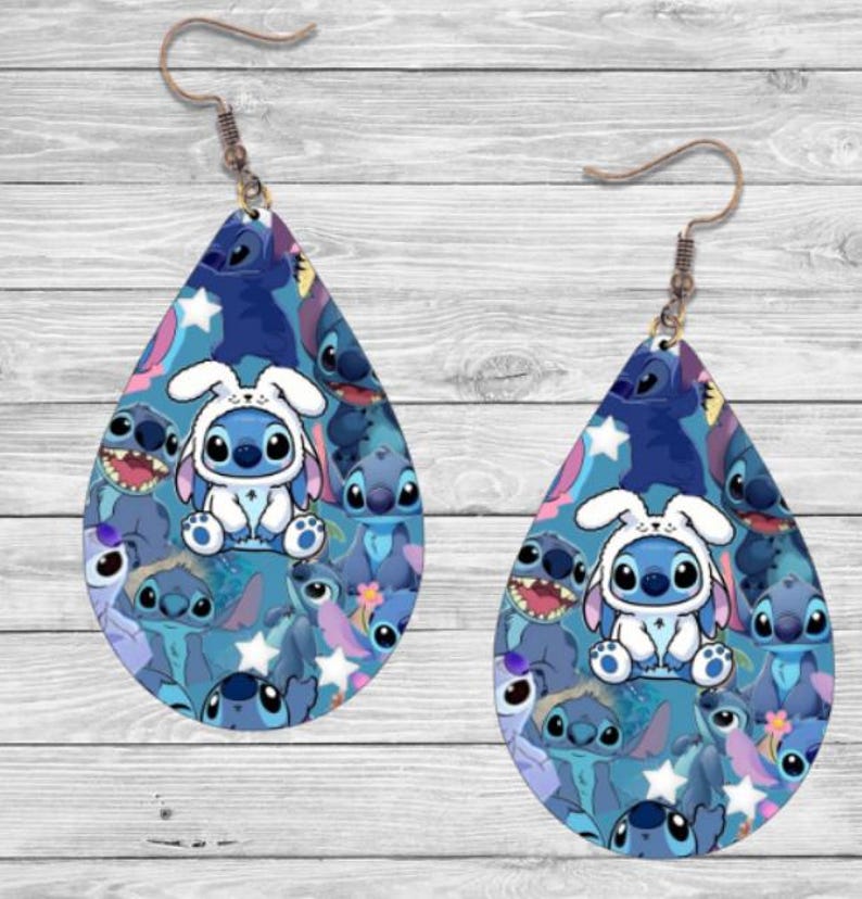 May include: A pair of blue teardrop-shaped earrings featuring a pattern of Stitch characters from the Disney film Lilo & Stitch. The earrings have a silver hook.