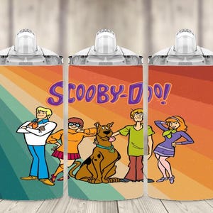 K&ouml;nnte beinhalten: Drei Trinkbecher mit den Scooby-Doo-Zeichentrickfiguren. Jeder Becher hat ein farbenfrohes Design mit den Figuren und dem Logo der Show. Der Hintergrund hat ein Retro-Regenbogen-Streifen-Design.