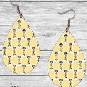 Peut inclure: Boucles d'oreilles en forme de goutte d'eau avec un fond jaune et un motif r&eacute;p&eacute;t&eacute; d'un personnage de dessin anim&eacute; en imperm&eacute;able jaune. Fermeture &agrave; crochet, finition m&eacute;tal marron clair.