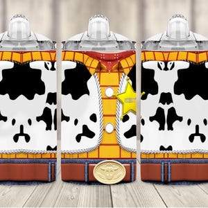 K&ouml;nnte beinhalten: Ein Satz von drei Trinkbechern mit einem Design, das von der Figur Woody aus Toy Story inspiriert wurde. Die Becher haben einen wei&szlig;en Hintergrund mit schwarzen Kuhflecken und ein Woody-Outfit-Design. Jeder Becher hat einen transparenten Deckel und einen wei&szlig;en Griff.