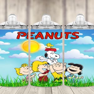 K&ouml;nnte beinhalten: Drei Trinkbecher mit einem farbenfrohen Design mit dem Wort "PEANUTS" in Rot. Die Becher zeigen Snoopy, Woodstock und andere Peanuts-Charaktere vor einem blauen Himmel mit Sonne und Wolken. Jeder Becher hat einen wei&szlig;en Griff.