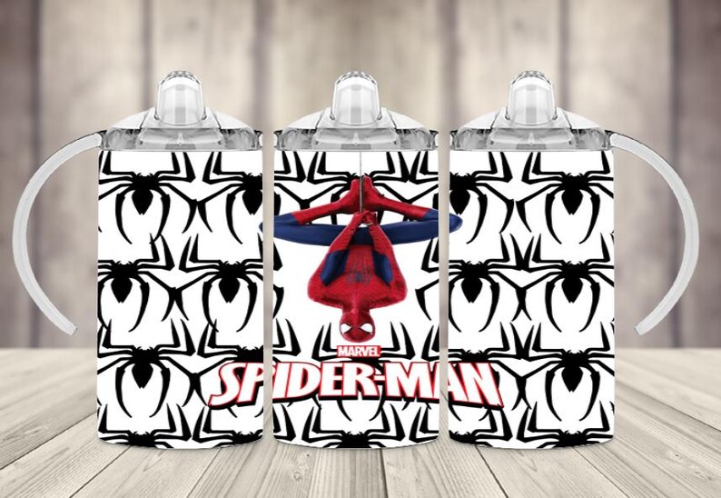 K&ouml;nnte beinhalten: Drei wei&szlig;e Trinkbecher mit Griffen. Zwei Becher haben ein schwarz-wei&szlig;es Spinnenmuster. Der mittlere Becher zeigt Spider-Man in einem rot-blauen Anzug mit den Marvel- und Spider-Man-Logos.