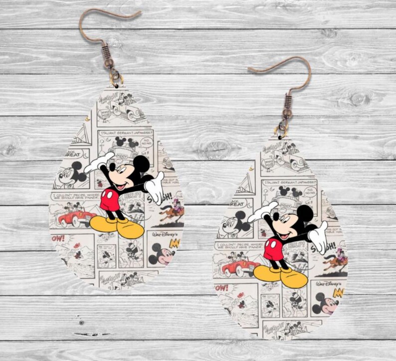 Op de afbeelding: Een paar druppelvormige oorbellen met een vintage Mickey Mouse stripontwerp. De oorbellen tonen Mickey in zijn rode broek, gele schoenen en witte handschoenen, tegen een zwart-witte stripachtergrond.