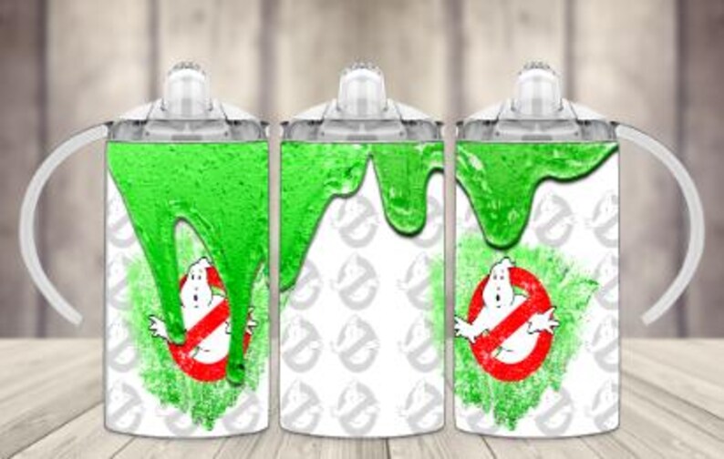 K&ouml;nnte beinhalten: Drei wei&szlig;e Trinkbecher mit Ghostbusters-Motiv. Jeder Becher hat ein gr&uuml;nes Schleimdesign und das Ghostbusters-Logo. Die Becher haben transparente Deckel und wei&szlig;e Griffe.